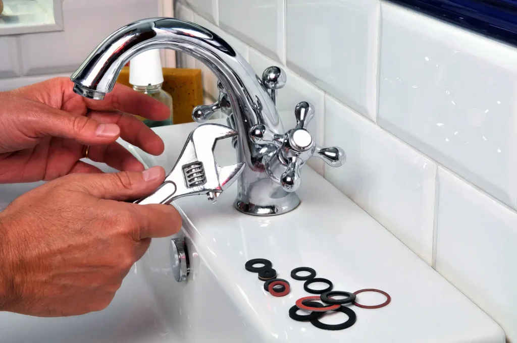 Plumber performing maintenance on a bathroom faucet in West Linn