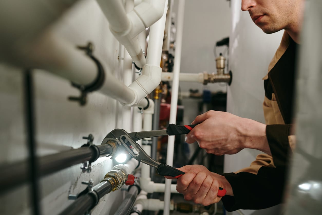 Plumbers maintaining commercial plumbing pipes in West Linn