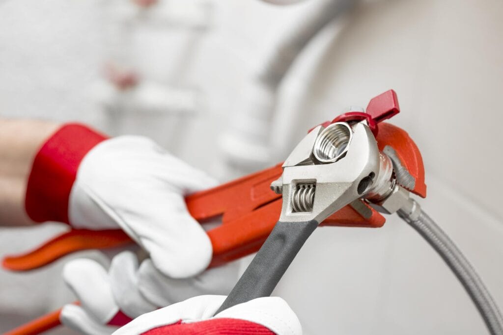 Plumber holding pipe wrenches for an emergency repair in West Linn