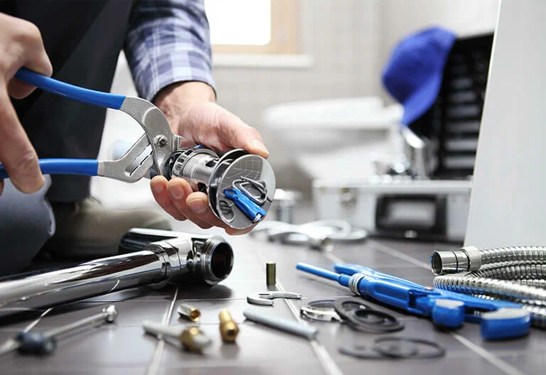Technician repairing a plumbing fixture with professional tools in West Linn
