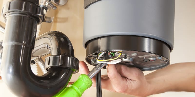 Technician repairing the heating element of a water heater in West Linn
