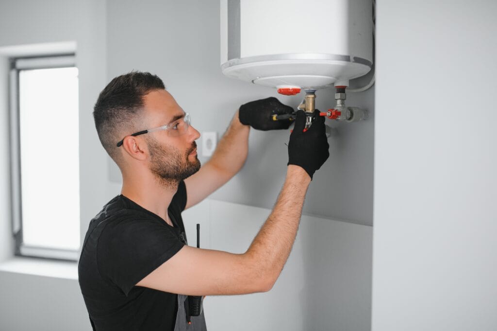 Technician performing water heater maintenance in West Linn