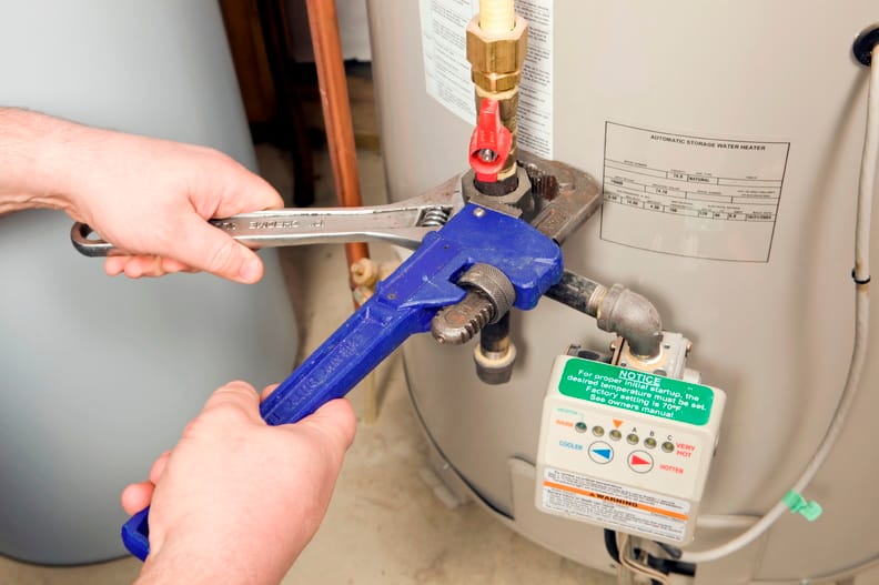 Plumber repairing a water heater valve in West Linn